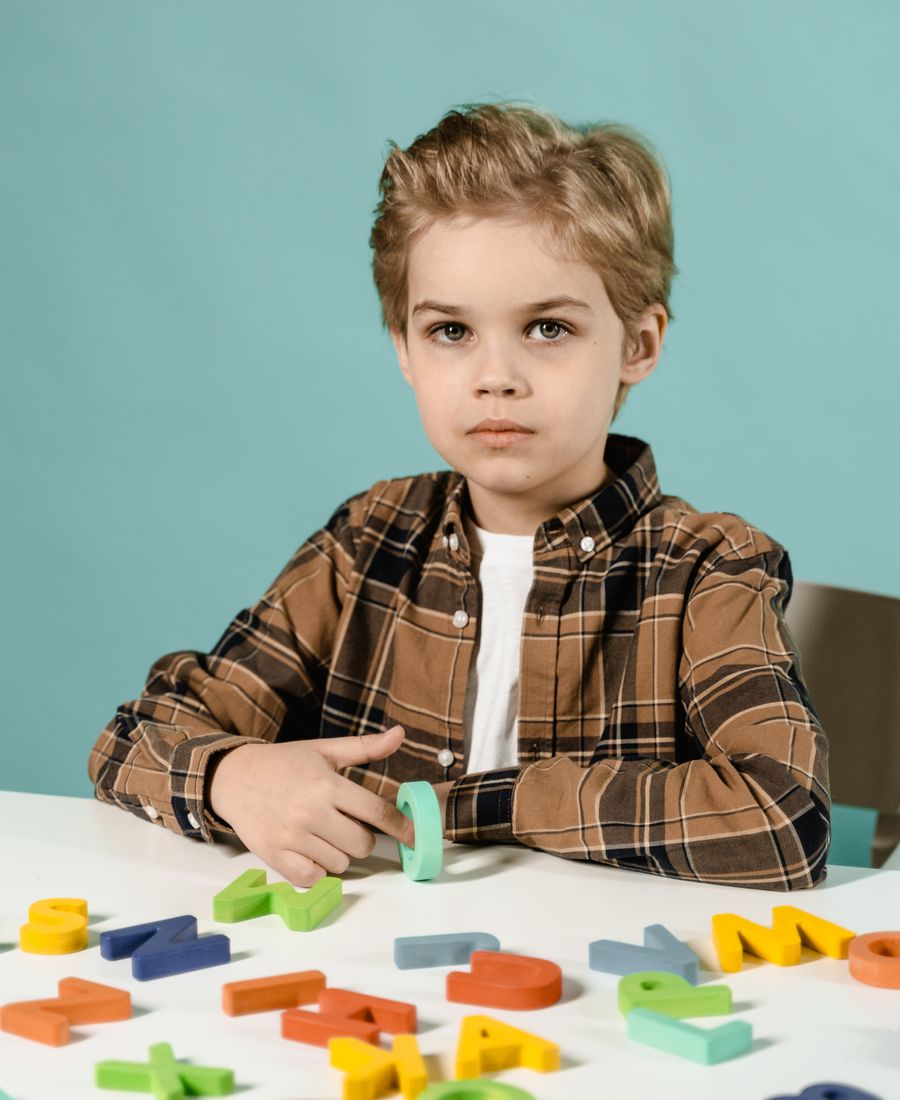 A young boy arranging colourful letter blocks